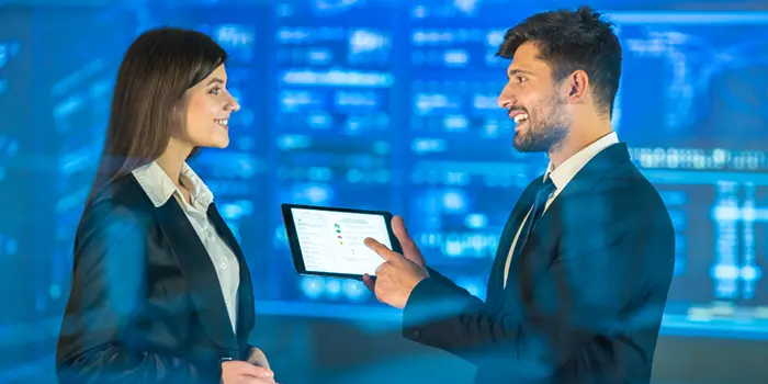 A man and woman in business attire examine a tablet, symbolizing collaboration in selecting the right SAP partner.