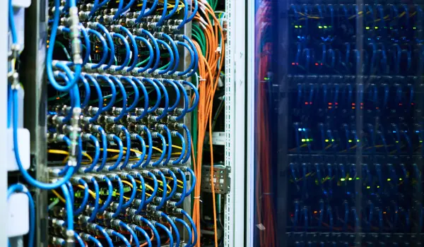 Networking, power, and auxiliary wires are being exposed from the server rack inside the data center.